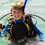 Family snorkeling with a Green Sea Turtle in the calm, shallow waters of Abu Dabbab Bay, Marsa Alam, perfect for holidays with kids.